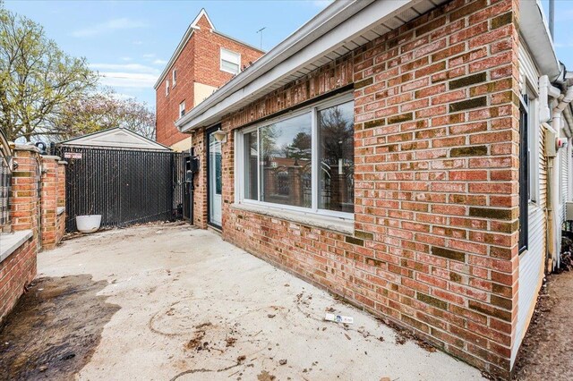 2738 Miles Ave, Bronx, NY 10465 - view of side of property with brick siding, fence, and a patio area