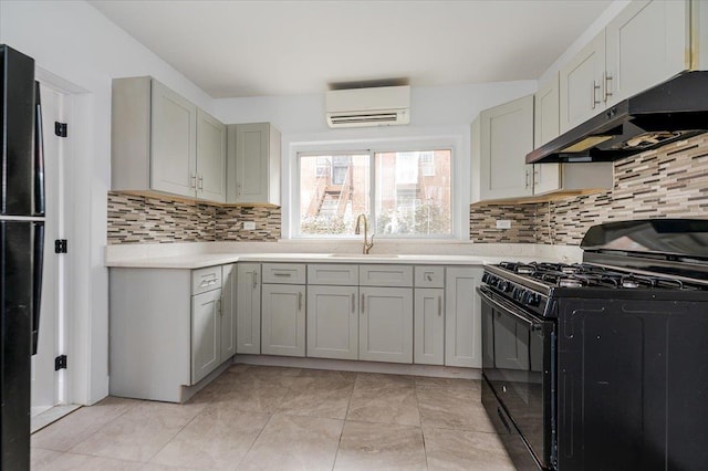 2738 Miles Ave, Bronx, NY 10465 - kitchen featuring black gas range oven, a wall mounted AC, light countertops, under cabinet range hood, and a sink