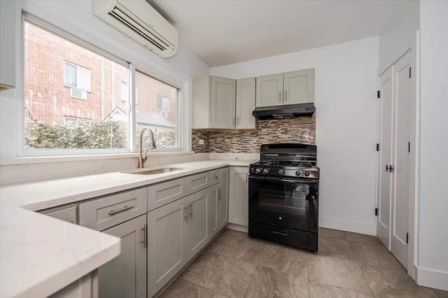 2738 Miles Ave, Bronx, NY 10465 - kitchen with an AC wall unit, under cabinet range hood, backsplash, a sink, and black gas stove