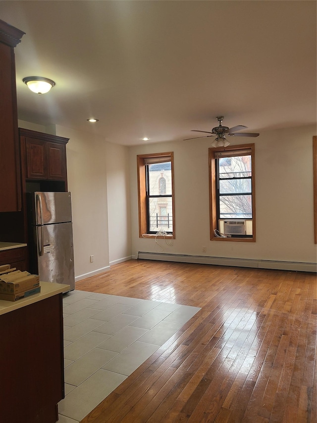 1871 Prospect Pl, Brooklyn, NY 11233 - unfurnished living room with baseboards, light wood-style floors, a baseboard heating unit, and a ceiling fan
