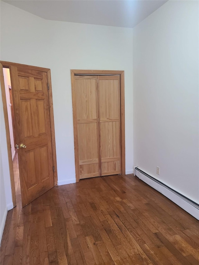 1871 Prospect Pl, Brooklyn, NY 11233 - unfurnished bedroom with a closet, dark wood-style floors, baseboards, and a baseboard heating unit