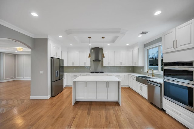 23 Grouse Ln, Levittown, NY 11756 - kitchen featuring wall chimney range hood, a sink, arched walkways, appliances with stainless steel finishes, and visible vents