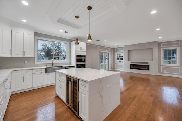 23 Grouse Ln, Levittown, NY 11756 - kitchen featuring a wealth of natural light, beverage cooler, a sink, and a kitchen island