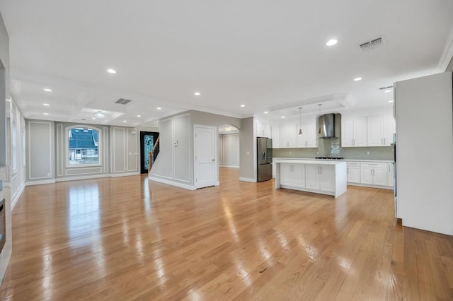 23 Grouse Ln, Levittown, NY 11756 - unfurnished living room with ornamental molding, light wood finished floors, visible vents, and recessed lighting