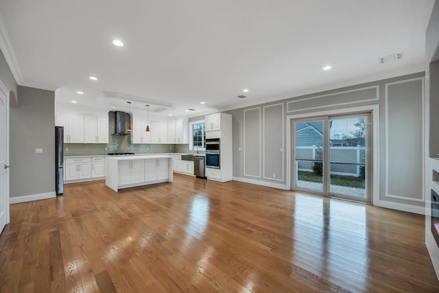23 Grouse Ln, Levittown, NY 11756 - kitchen featuring wall chimney range hood, ornamental molding, black appliances, and a decorative wall