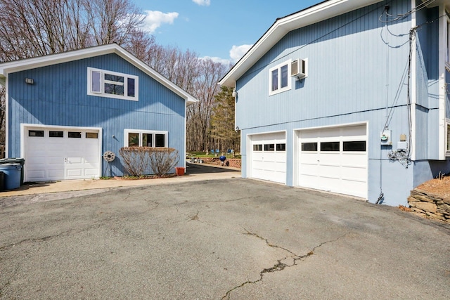 view of side of property with an attached garage and a wall mounted AC