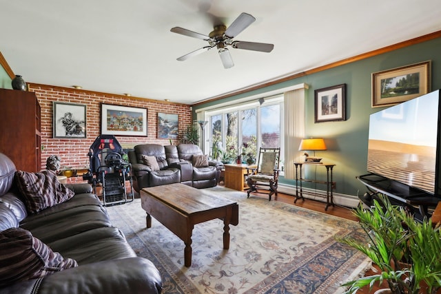 living room with baseboards, brick wall, a ceiling fan, crown molding, and a baseboard heating unit