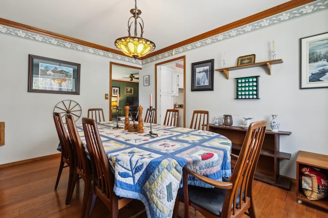 dining area with wood finished floors, ceiling fan, baseboards, and ornamental molding