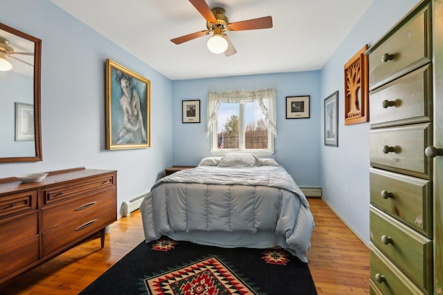 bedroom with baseboard heating, light wood-style floors, and ceiling fan