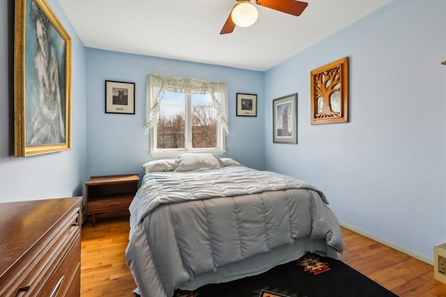 bedroom featuring light wood-type flooring, baseboards, and a ceiling fan