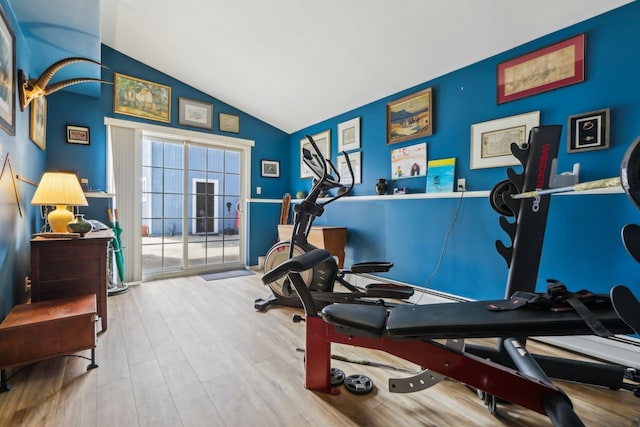 exercise area featuring vaulted ceiling and wood finished floors