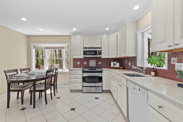kitchen with a sink, white cabinetry, appliances with stainless steel finishes, and light countertops
