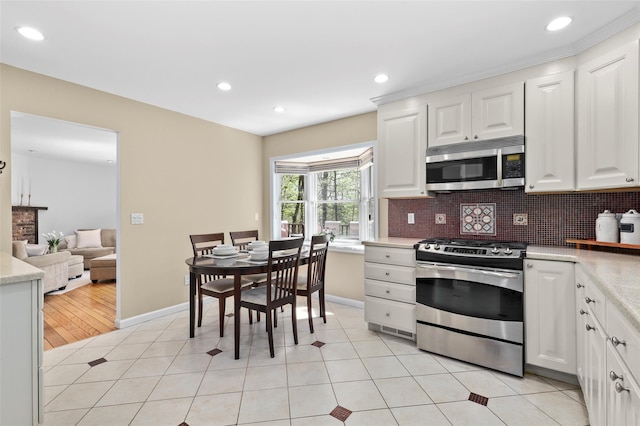 kitchen with light countertops, stainless steel appliances, white cabinets, and recessed lighting