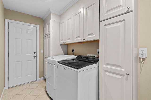laundry area featuring cabinet space, crown molding, washing machine and clothes dryer, baseboards, and light tile patterned floors