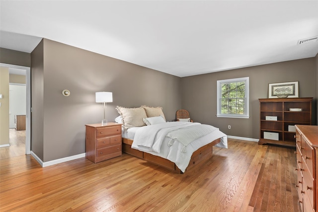 bedroom featuring light wood-style floors, baseboards, and visible vents