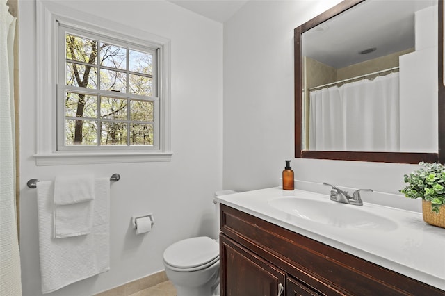 bathroom with toilet, tile patterned floors, baseboards, and vanity