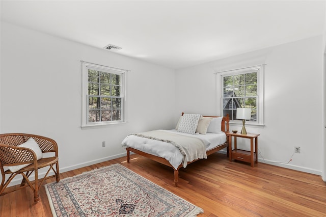 bedroom featuring light wood-style floors, baseboards, and visible vents