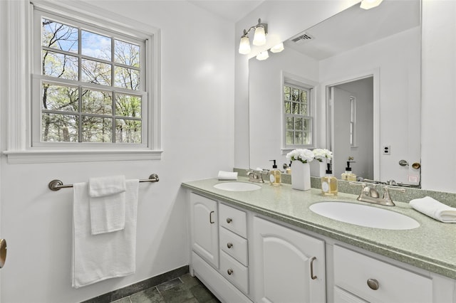 full bath featuring visible vents, a sink, baseboards, and double vanity