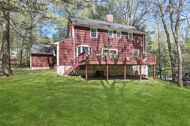 back of house with a lawn, a shingled roof, a wooden deck, and a chimney