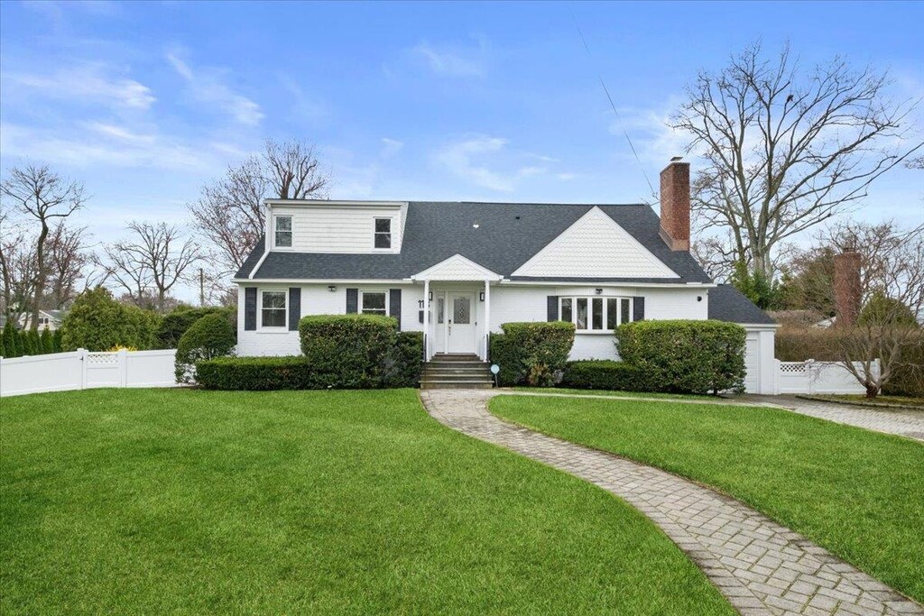 118 New Wilmot Rd, Scarsdale, NY 10583 - view of front facade featuring roof with shingles, a chimney, fence private yard, and a front lawn