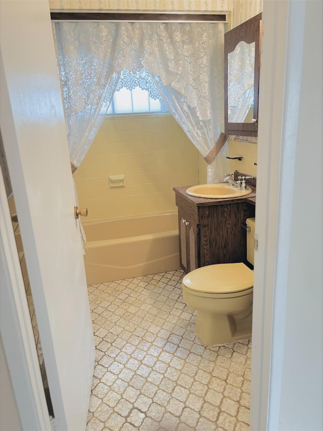 bathroom with a washtub, vanity, tile patterned floors, and toilet