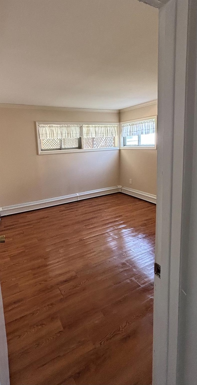 unfurnished room with baseboards and dark wood-style flooring