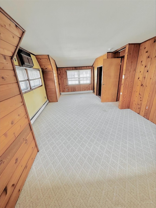 unfurnished room with wooden walls, light colored carpet, and a baseboard radiator
