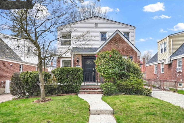 view of front of house featuring a front yard, fence, brick siding, and cooling unit
