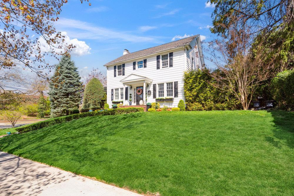 1 Chestnut St, Garden City, NY 11530 - colonial house featuring a chimney and a front yard