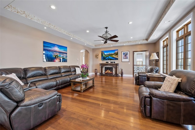 117 Malba Dr, Malba, NY 11357 - living area featuring a ceiling fan, wood finished floors, arched walkways, a tray ceiling, and recessed lighting