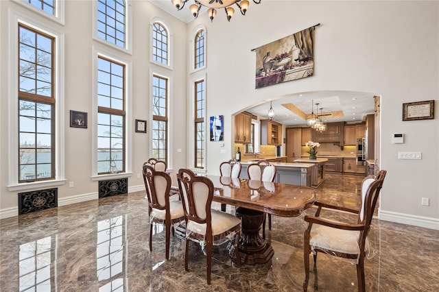 117 Malba Dr, Malba, NY 11357 - dining space featuring marble finish floor, an inviting chandelier, a high ceiling, and baseboards