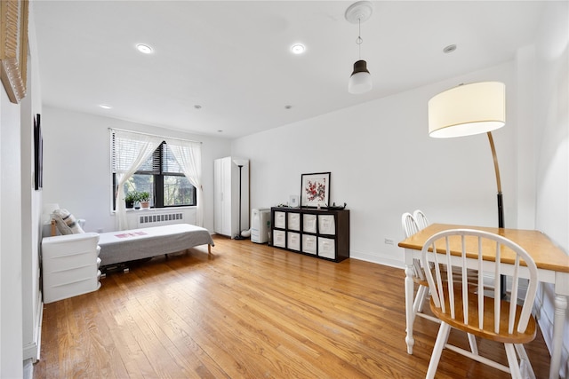 bedroom featuring recessed lighting, light wood-style flooring, and radiator
