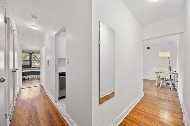 hallway featuring light wood-style floors and baseboards