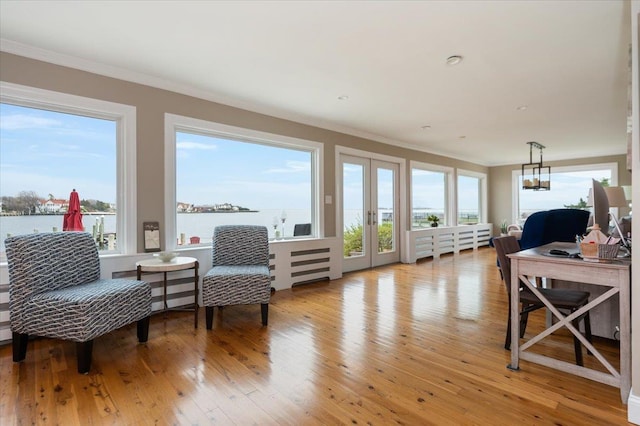 sunroom / solarium with french doors and a water view