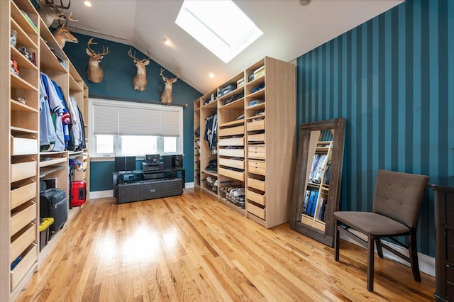 walk in closet with lofted ceiling with skylight and wood finished floors