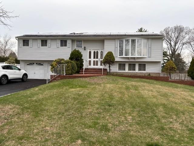 19 Yeoman Dr, East Northport, NY 11731 - bi-level home with an attached garage, aphalt driveway, entry steps, a front lawn, and solar panels