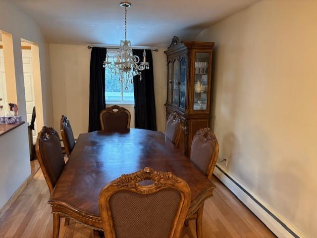 19 Yeoman Dr, East Northport, NY 11731 - dining area with a notable chandelier, light wood-style floors, and a baseboard heating unit