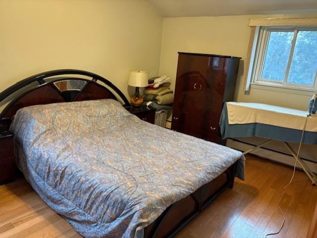 19 Yeoman Dr, East Northport, NY 11731 - bedroom featuring a baseboard heating unit and hardwood / wood-style floors