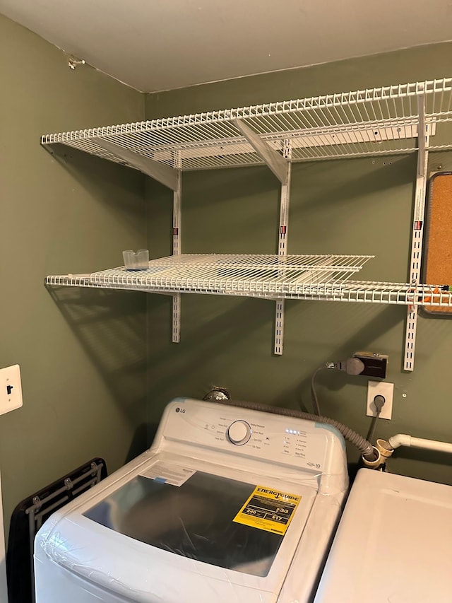 clothes washing area featuring washer / clothes dryer and laundry area
