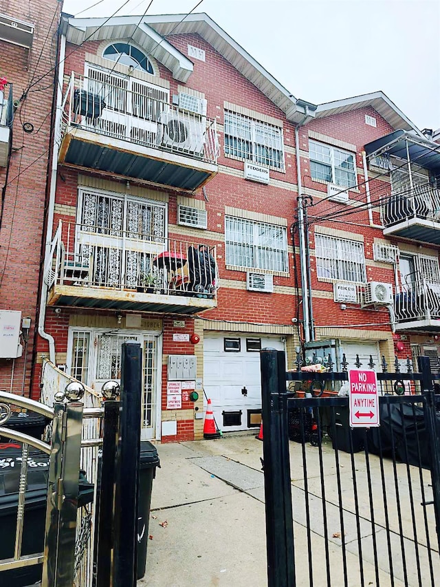 108-14 35th Ave, Corona, NY 11368 - view of building exterior with a wall mounted air conditioner, a garage, and concrete driveway