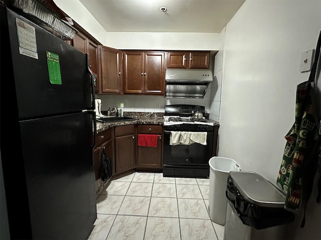 108-14 35th Ave, Corona, NY 11368 - kitchen featuring dark countertops, dark brown cabinets, under cabinet range hood, gas range, and freestanding refrigerator