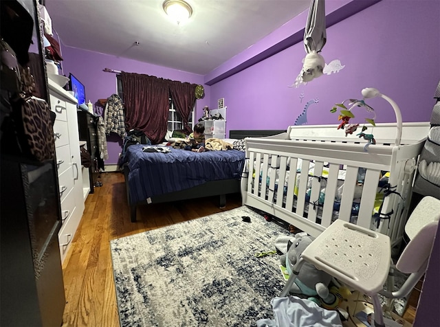 108-14 35th Ave, Corona, NY 11368 - bedroom with wood finished floors and a baseboard heating unit