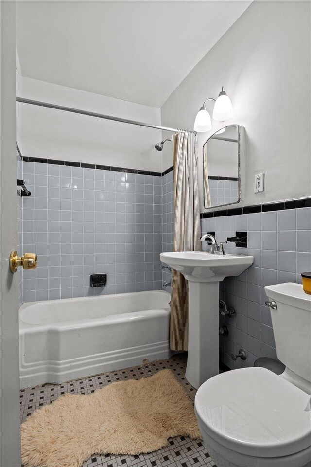 5550 Fieldston Rd Unit 7C, Bronx, NY 10471 - bathroom featuring toilet, tile walls, shower / bath combo, tile patterned floors, and wainscoting