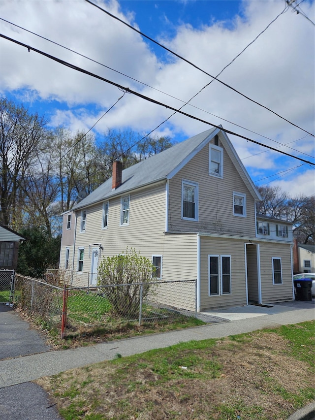 exterior space featuring a chimney and a fenced front yard