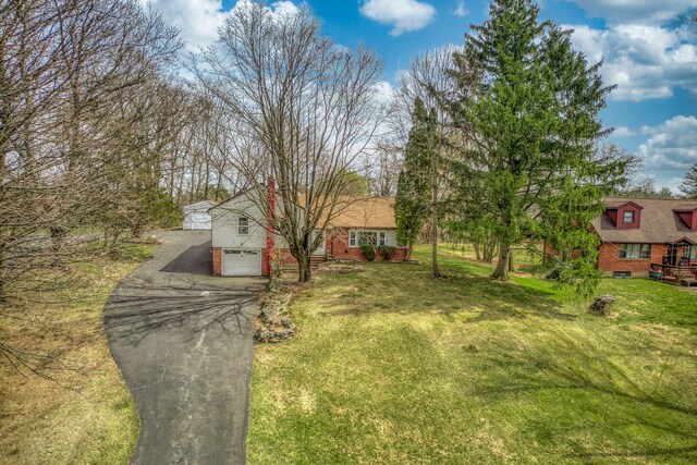 view of front of house with driveway, a front yard, and a garage