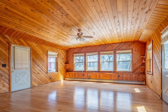 unfurnished living room with a baseboard radiator, plenty of natural light, wood finished floors, and lofted ceiling