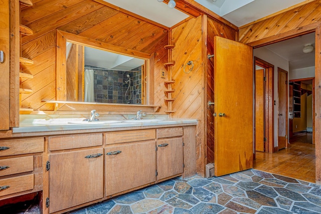 bathroom featuring wood walls, vanity, and stone tile floors