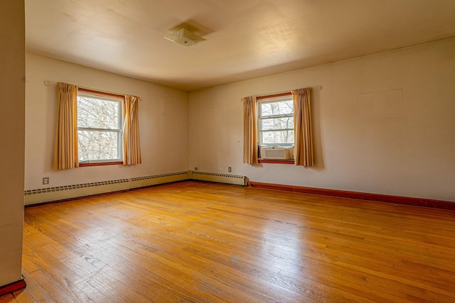 unfurnished room with a baseboard radiator, light wood-style flooring, baseboards, and cooling unit