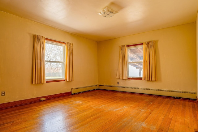 spare room with a baseboard radiator and light wood finished floors