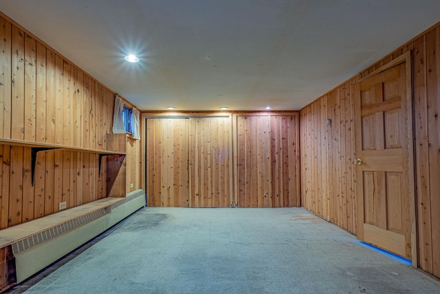 spare room with tile patterned floors, radiator, wooden walls, and recessed lighting